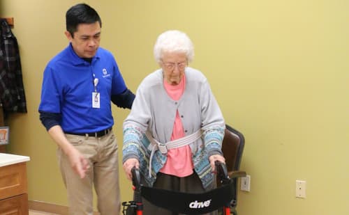 Nurse assisting patient during stroke rehabilitation therapy