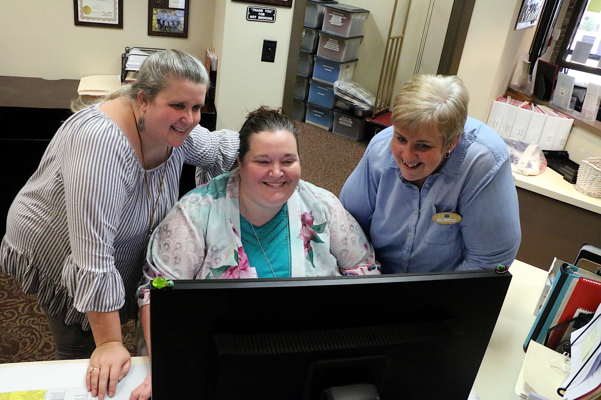 Three Saint Anthony employees laughing and chatting.