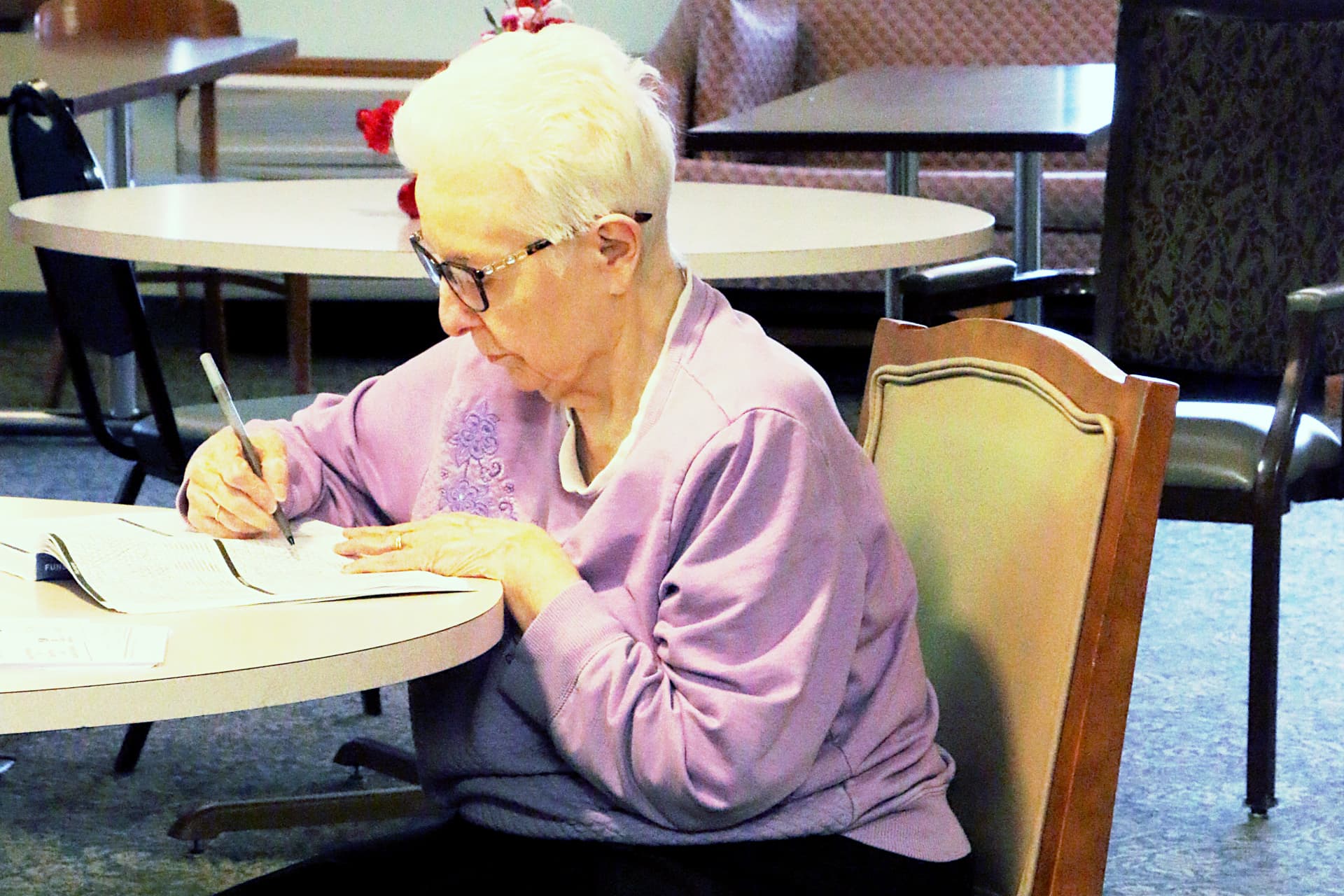 Elderly woman working on crossword puzzle