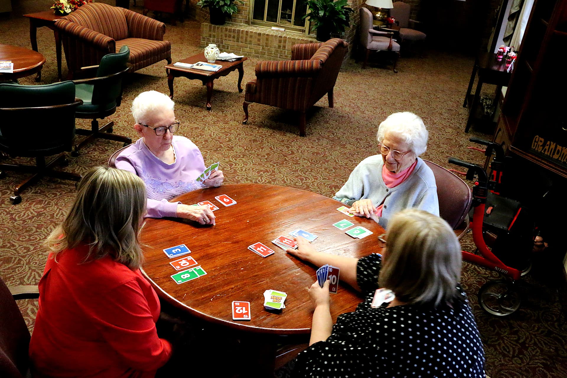 Group of residents and staff playing cards at table
