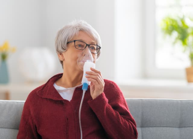 Elderly woman using an inhaler